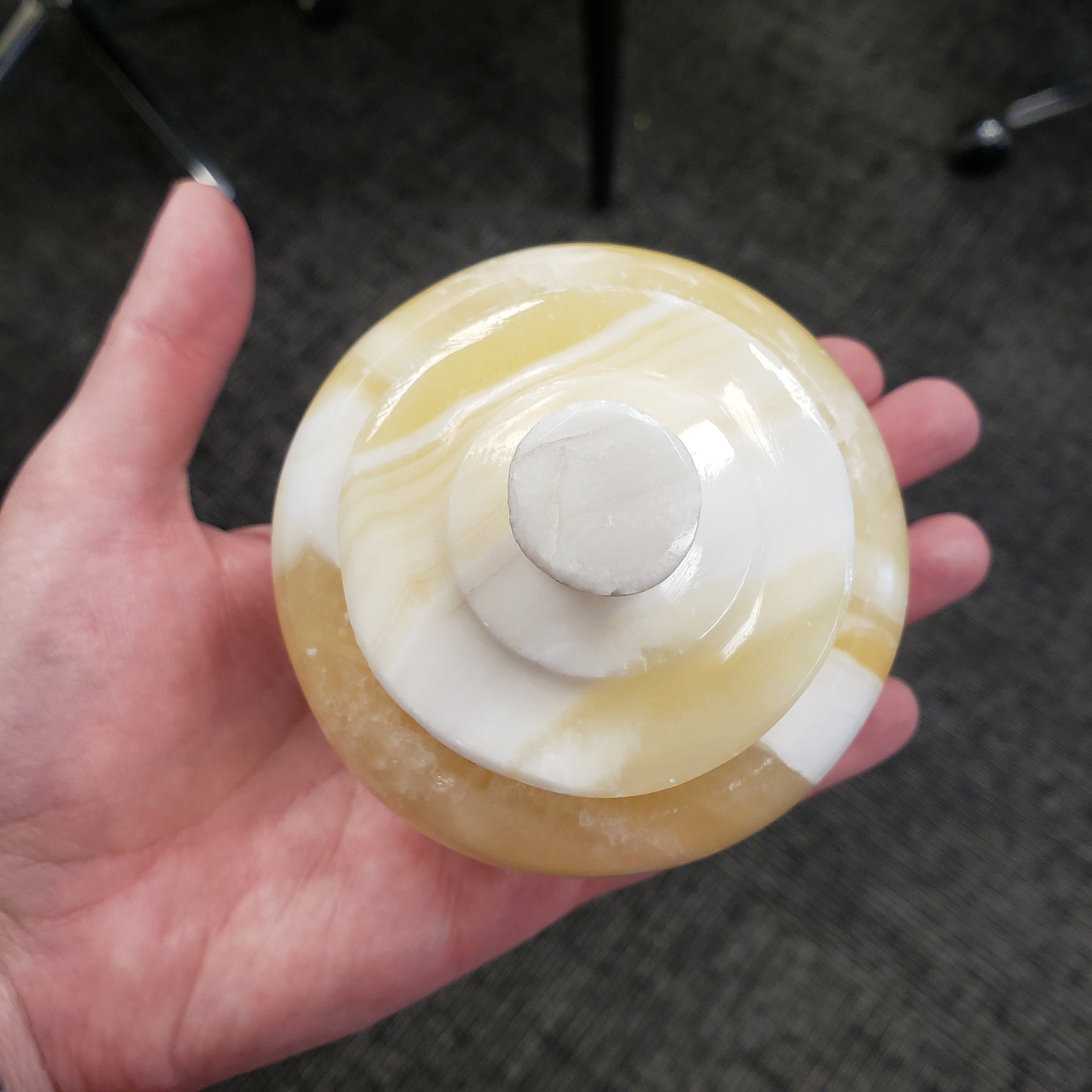 Hand holding a round object with a white center and yellowish-brown exterior.