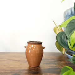 Ceramic vase on a wooden surface with a white background
