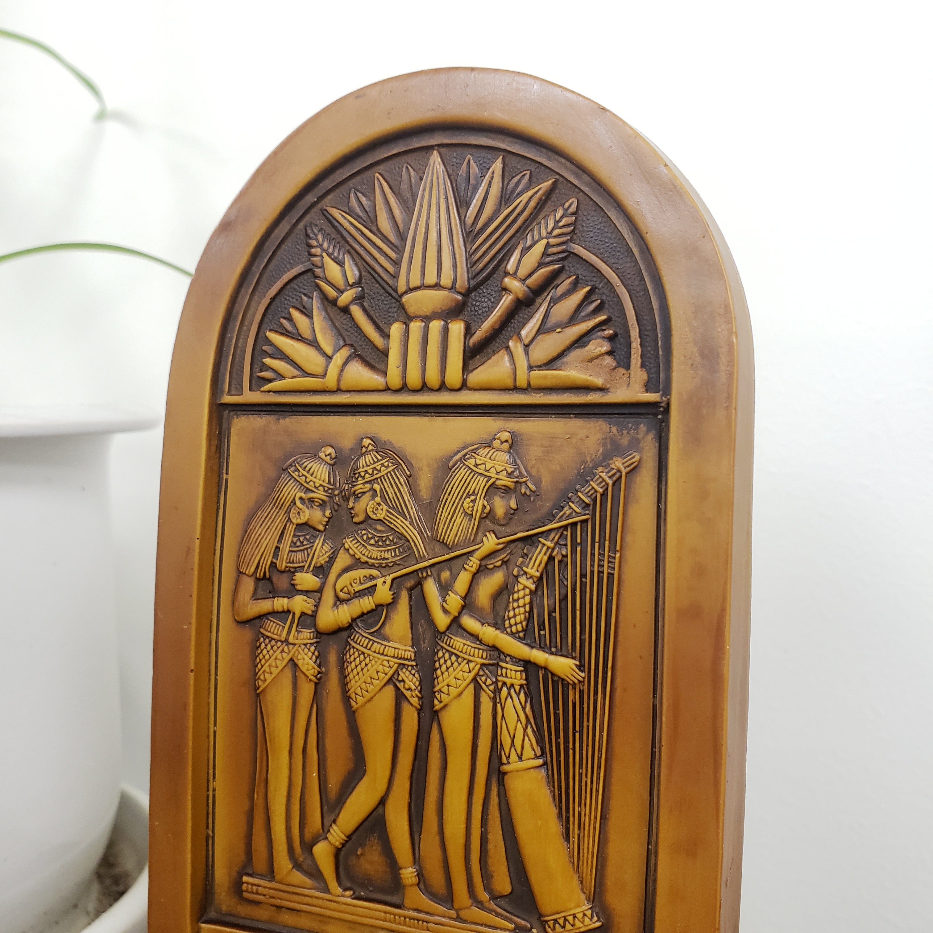 Decorative plaque with intricate carvings on a white background