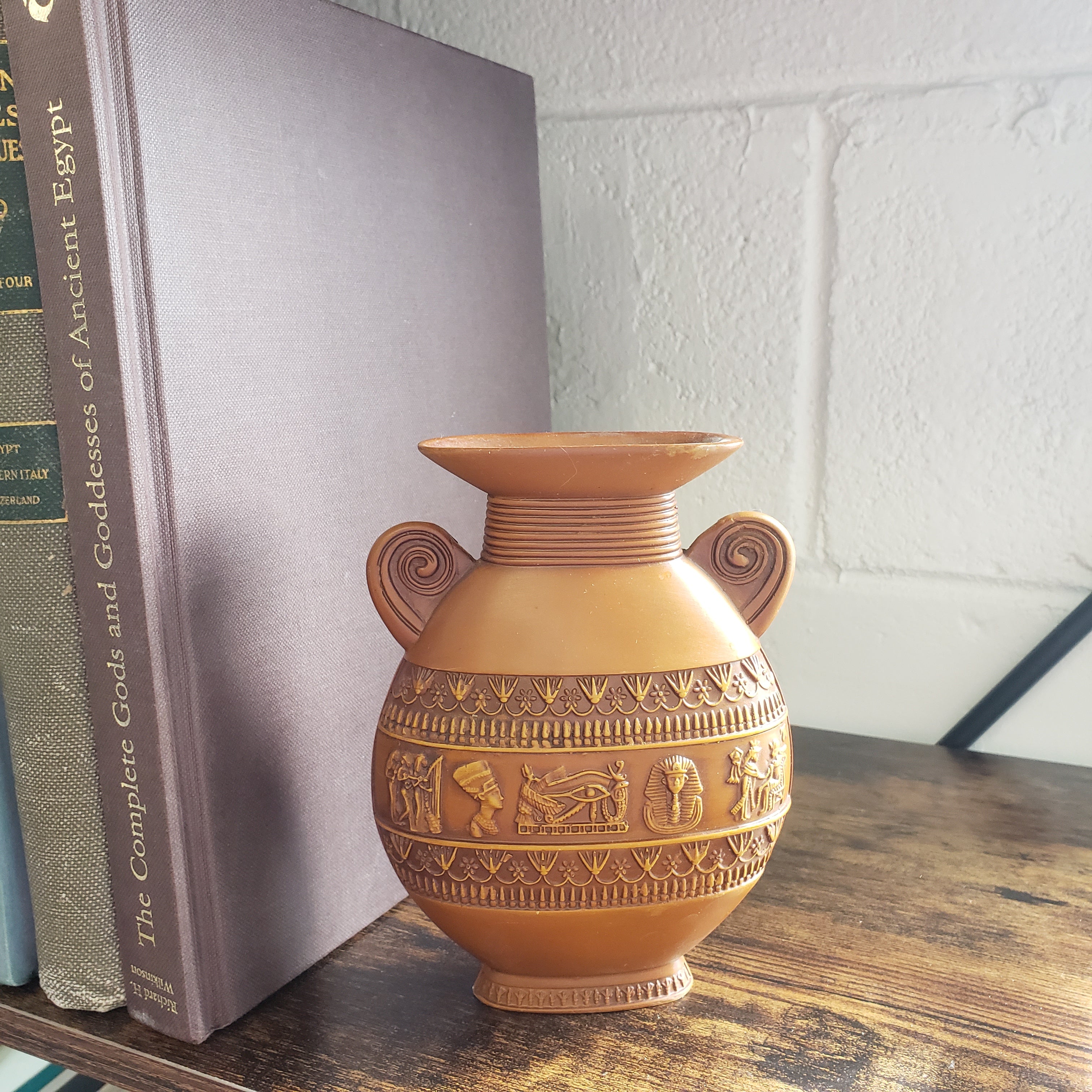 Decorative vase with intricate patterns on a stack of books