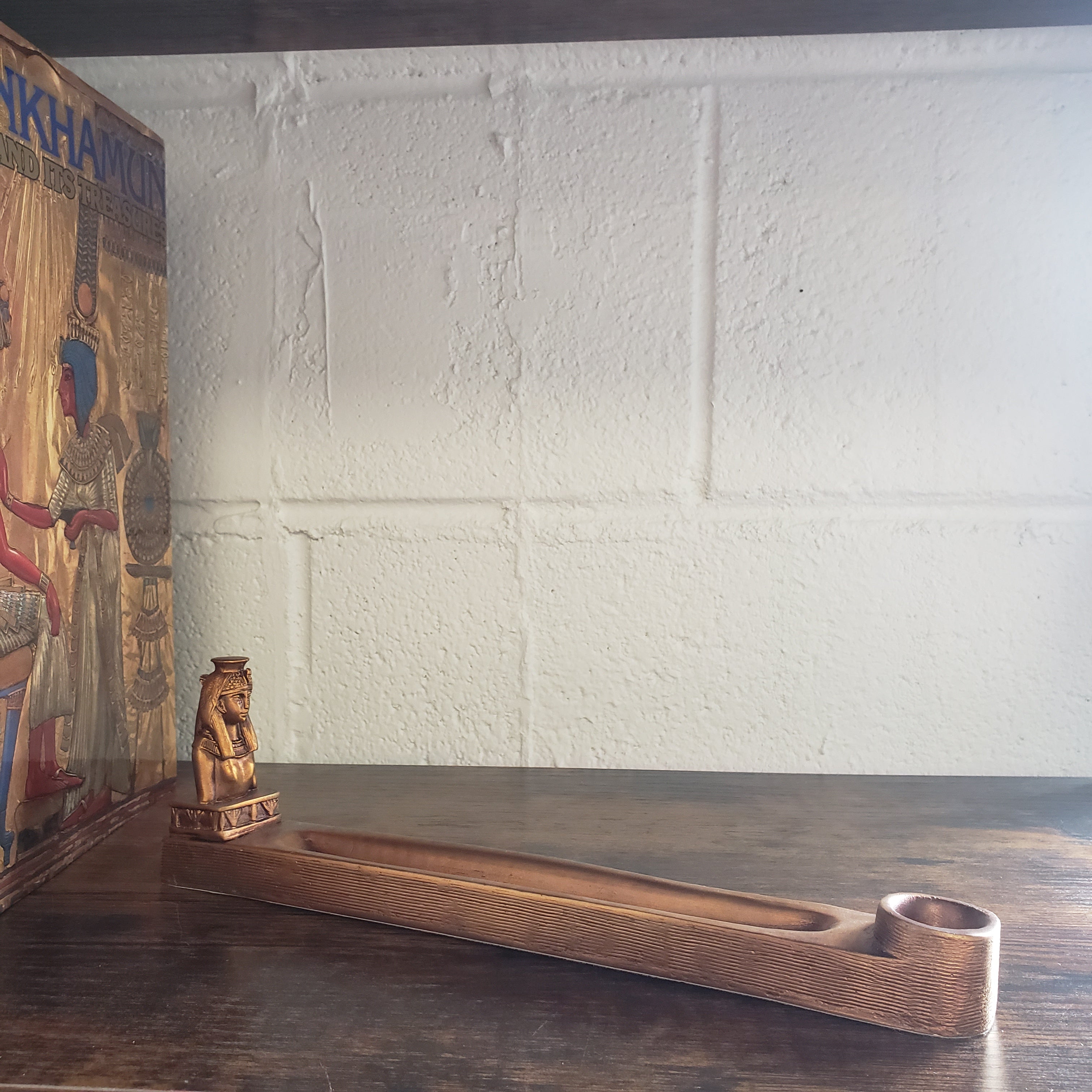 Incense holder against a white brick wall