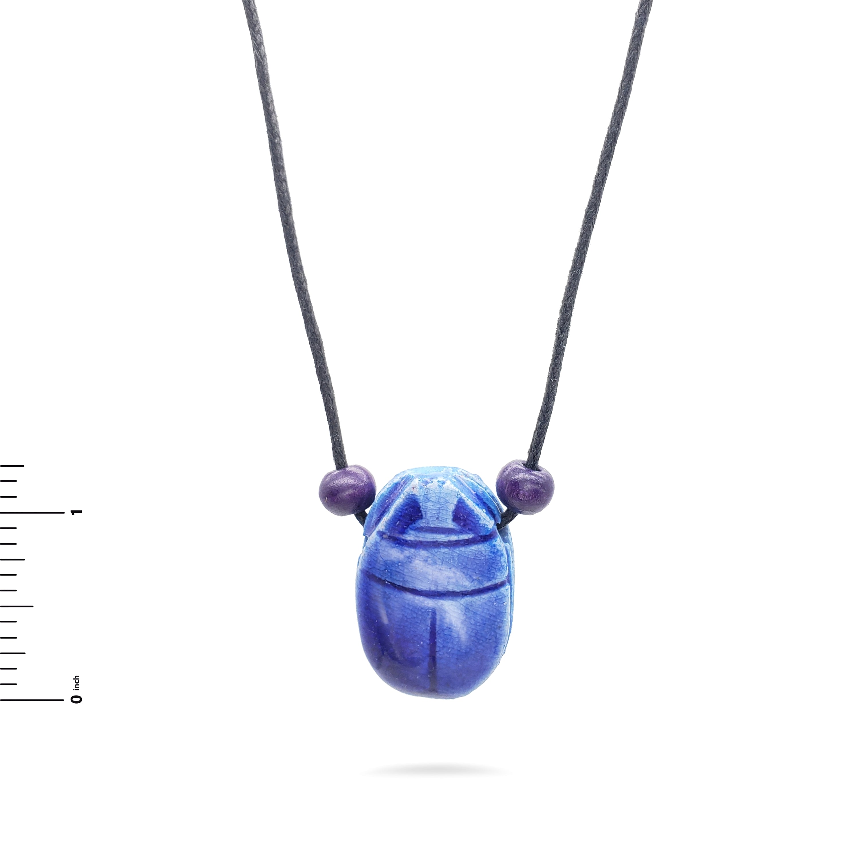 Blue scarab necklace with purple beads on a white background
