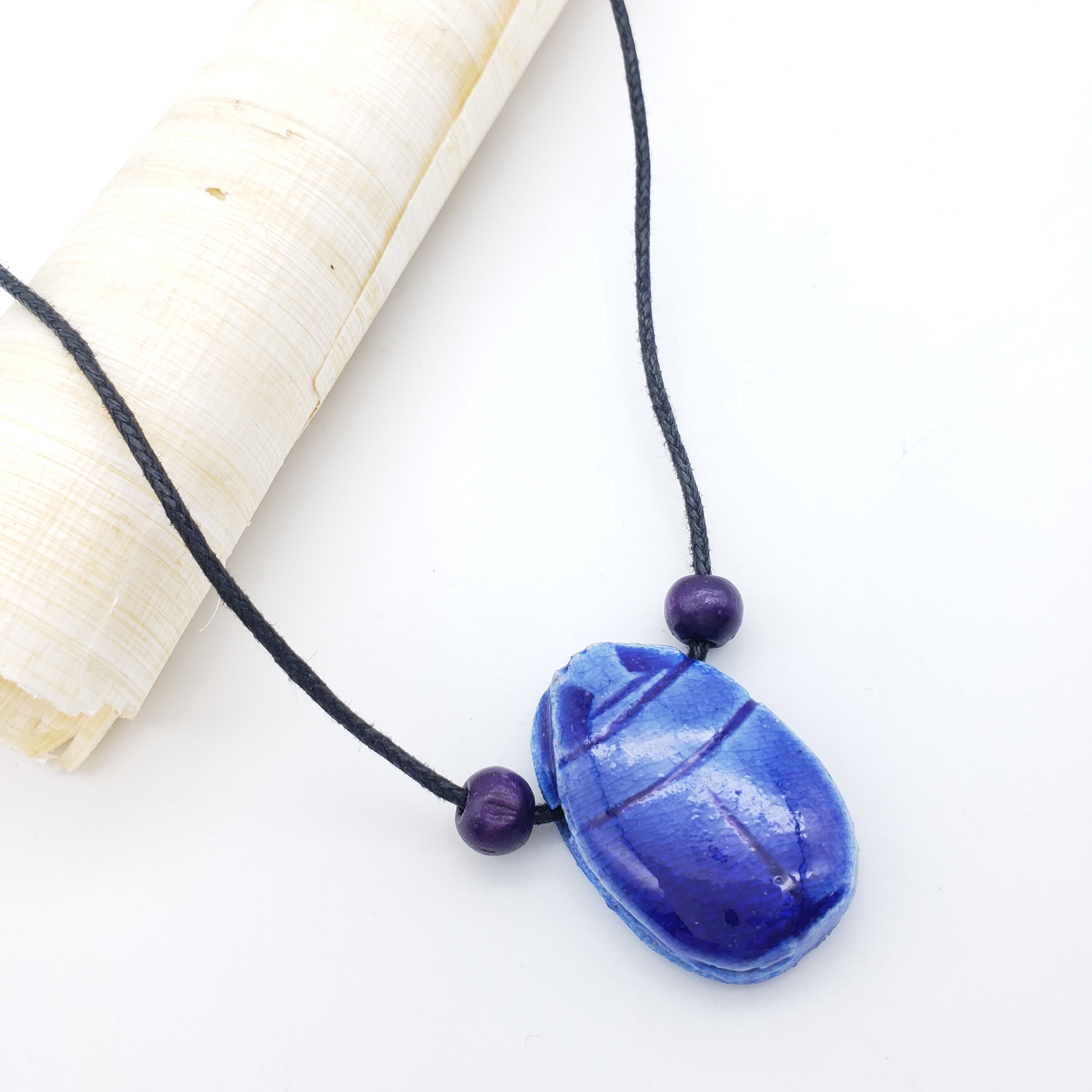 Blue scarab necklace on a white background