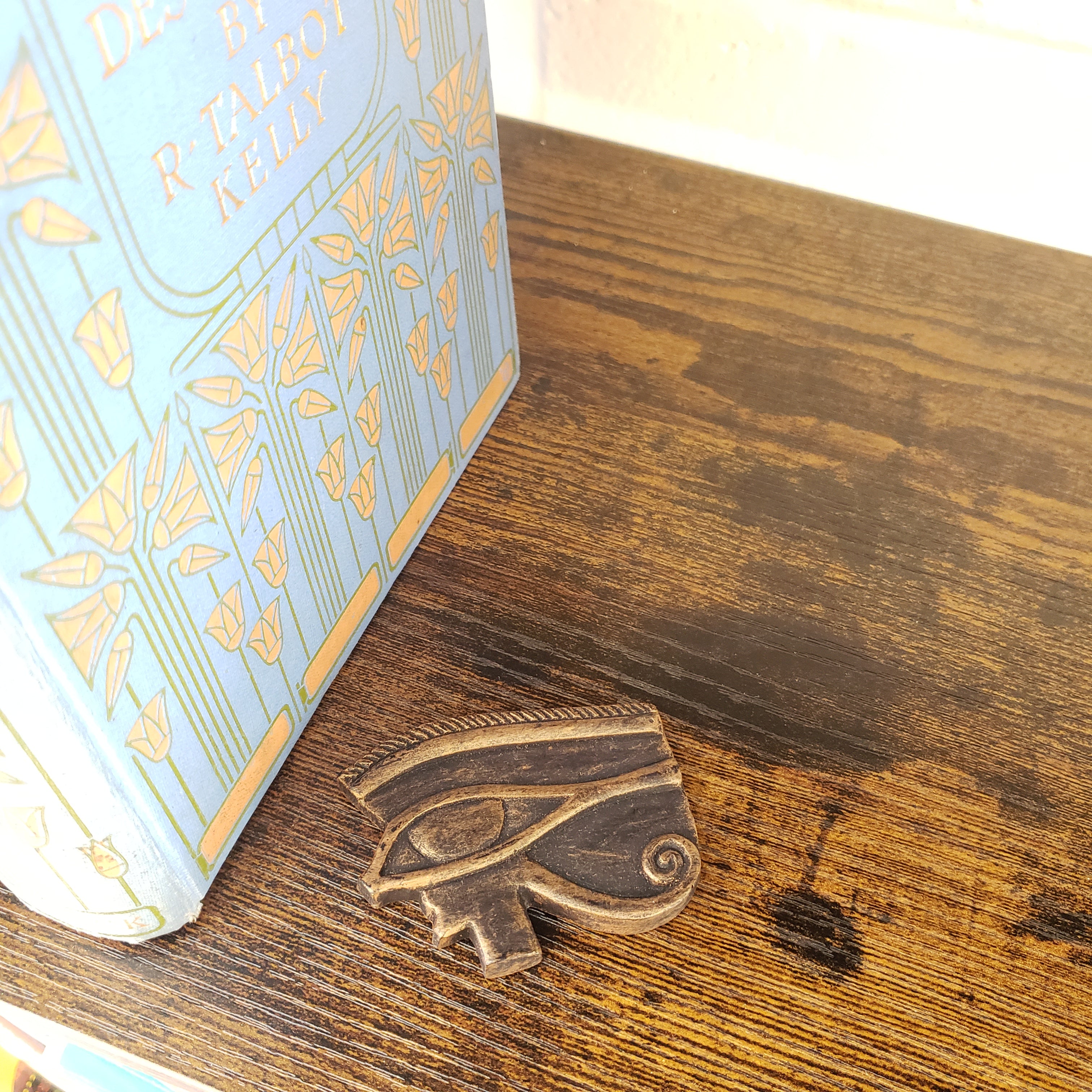 Decorative book corner with a wooden shelf and decorative emblem.