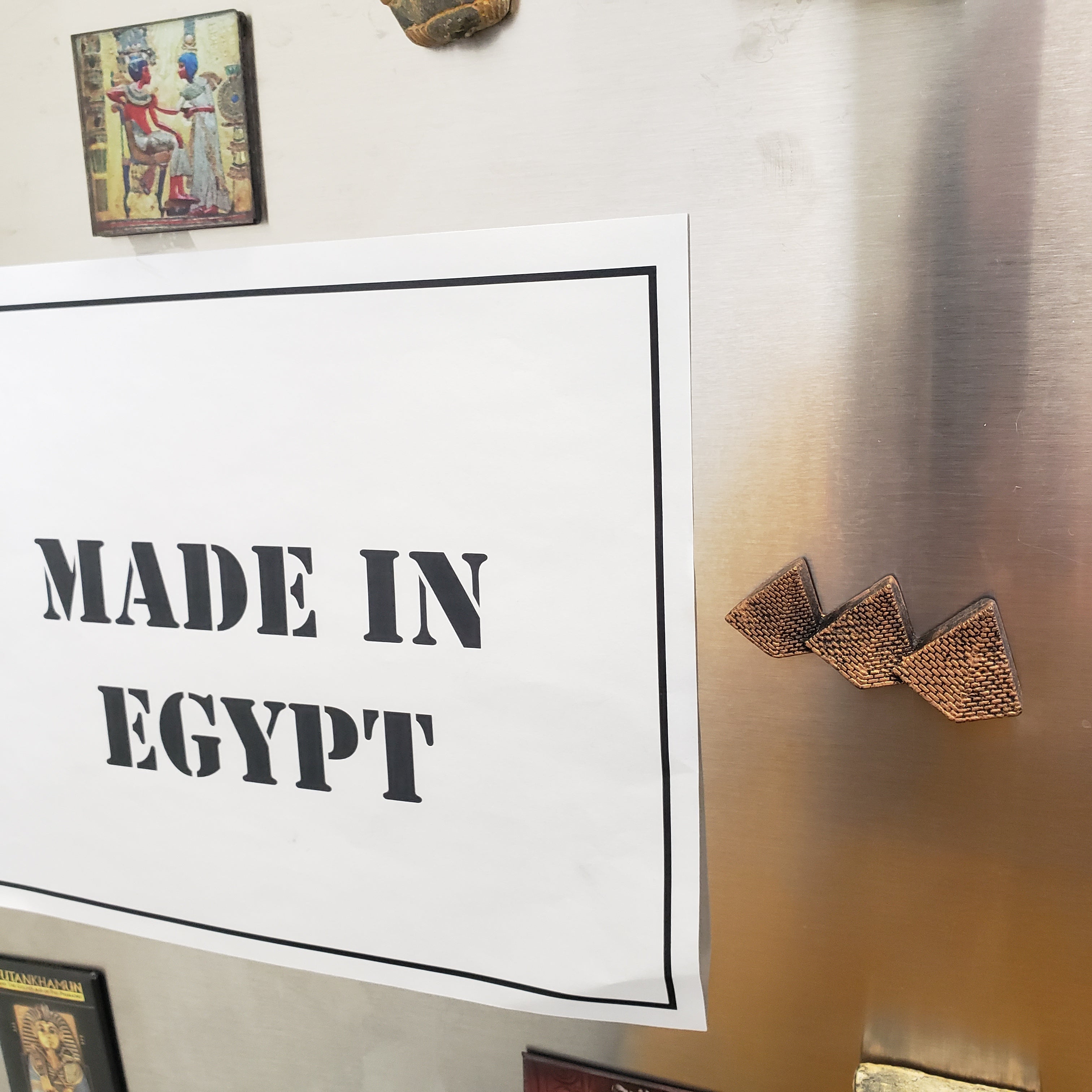 Poster with 'MADE IN EGYPT' text on a wall with decorative elements.