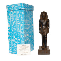 An Egyptian-style pharaoh statue in dark bronze standing next to its blue box with white hieroglyphic patterns and a small product label.