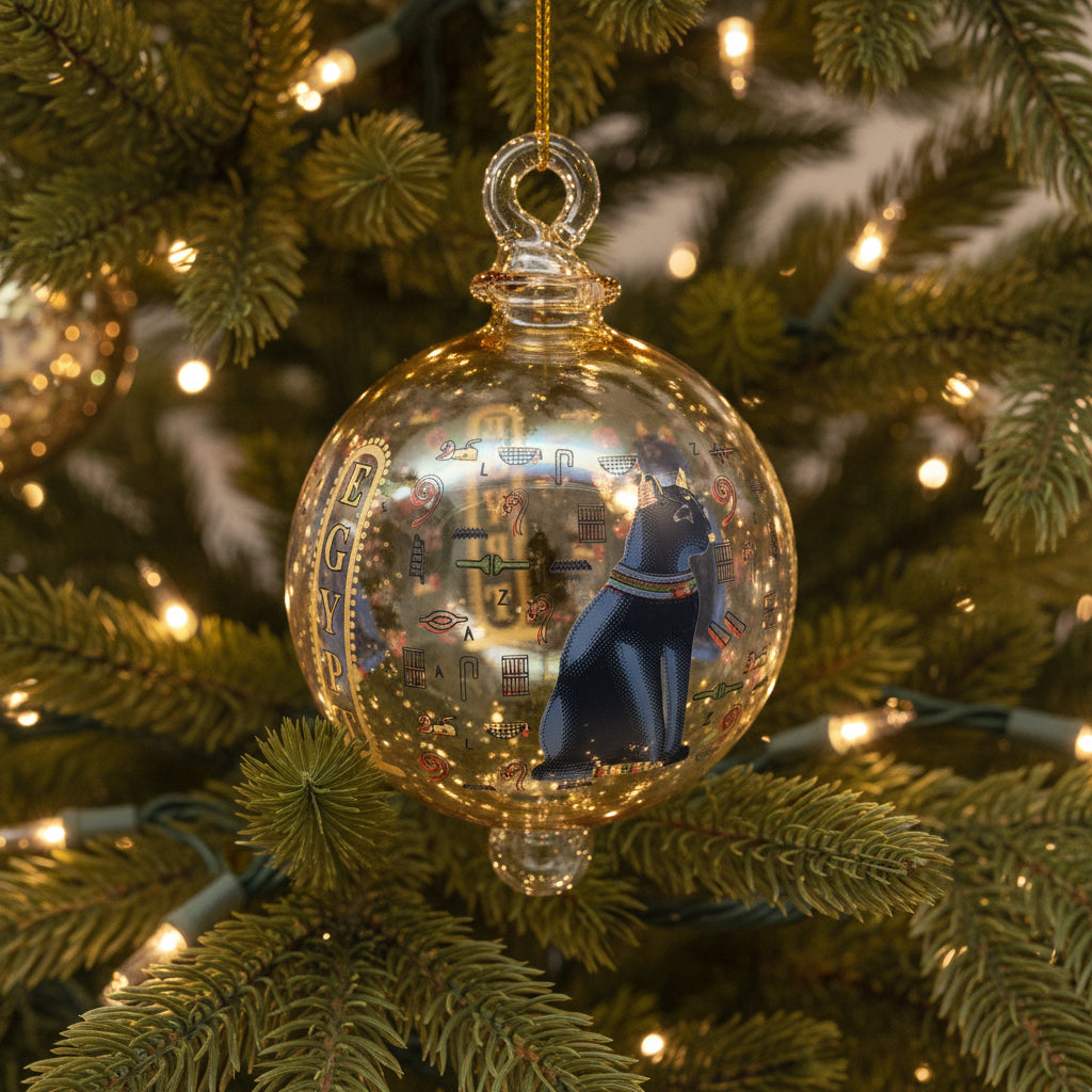 Decorative glass ball ornament with Egyptian-themed design on a white background