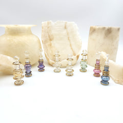Set of glass bottles with colorful stoppers on a white background