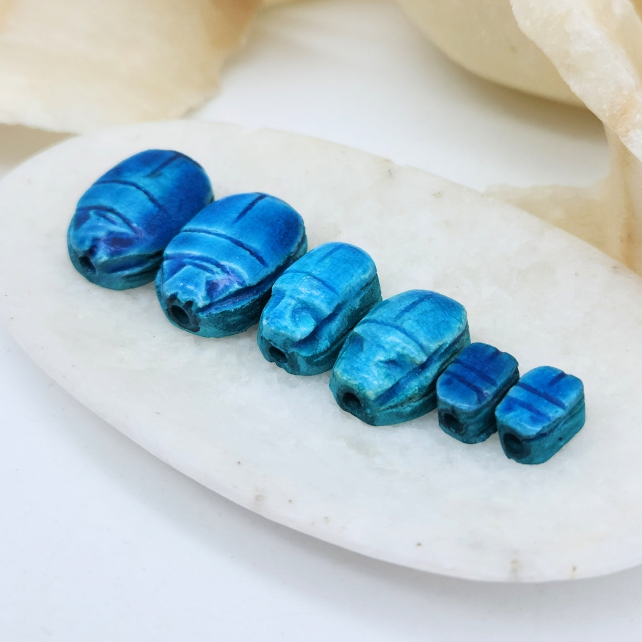 Set of blue stone beads on a white surface