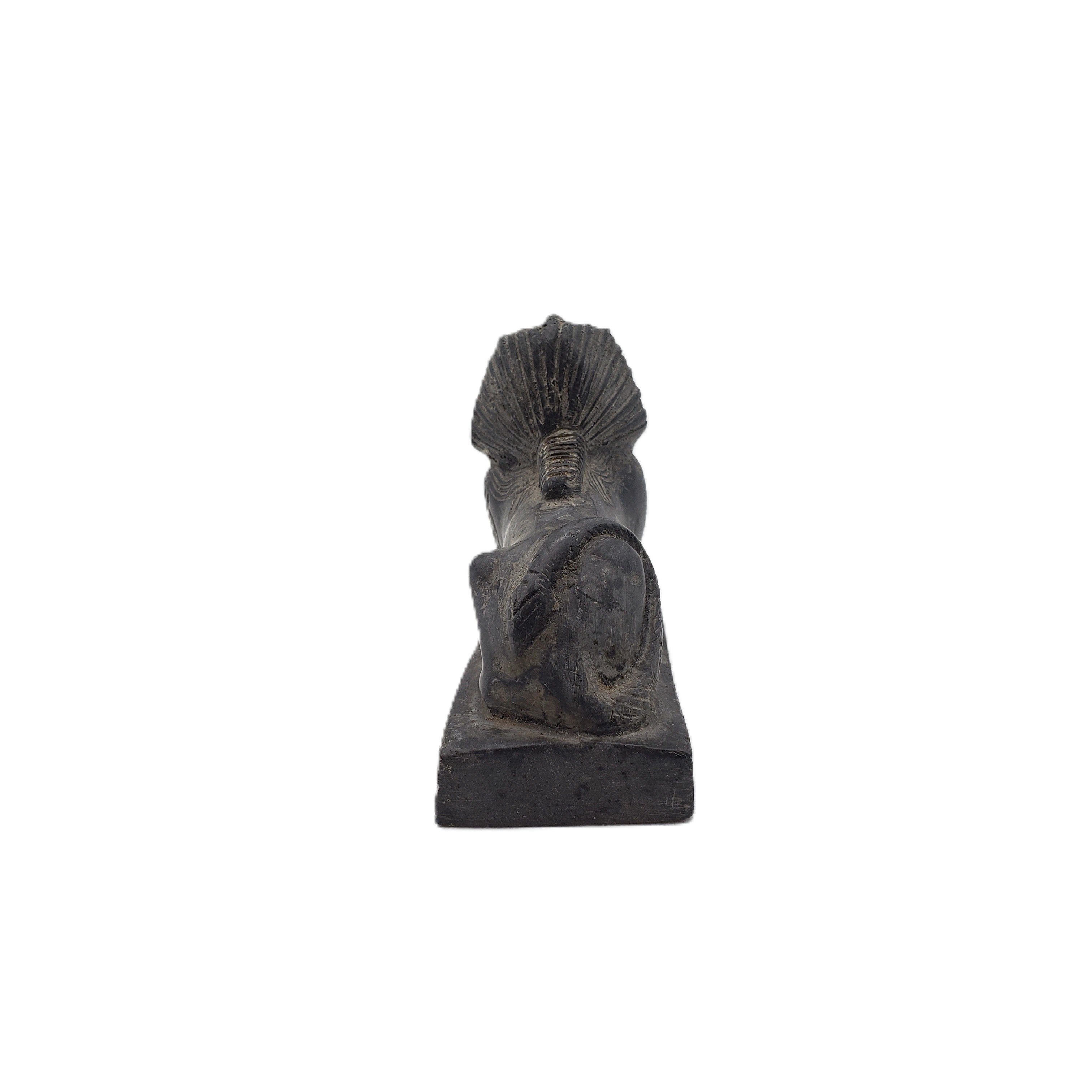 Black stone sculpture of a sphinx on a white background
