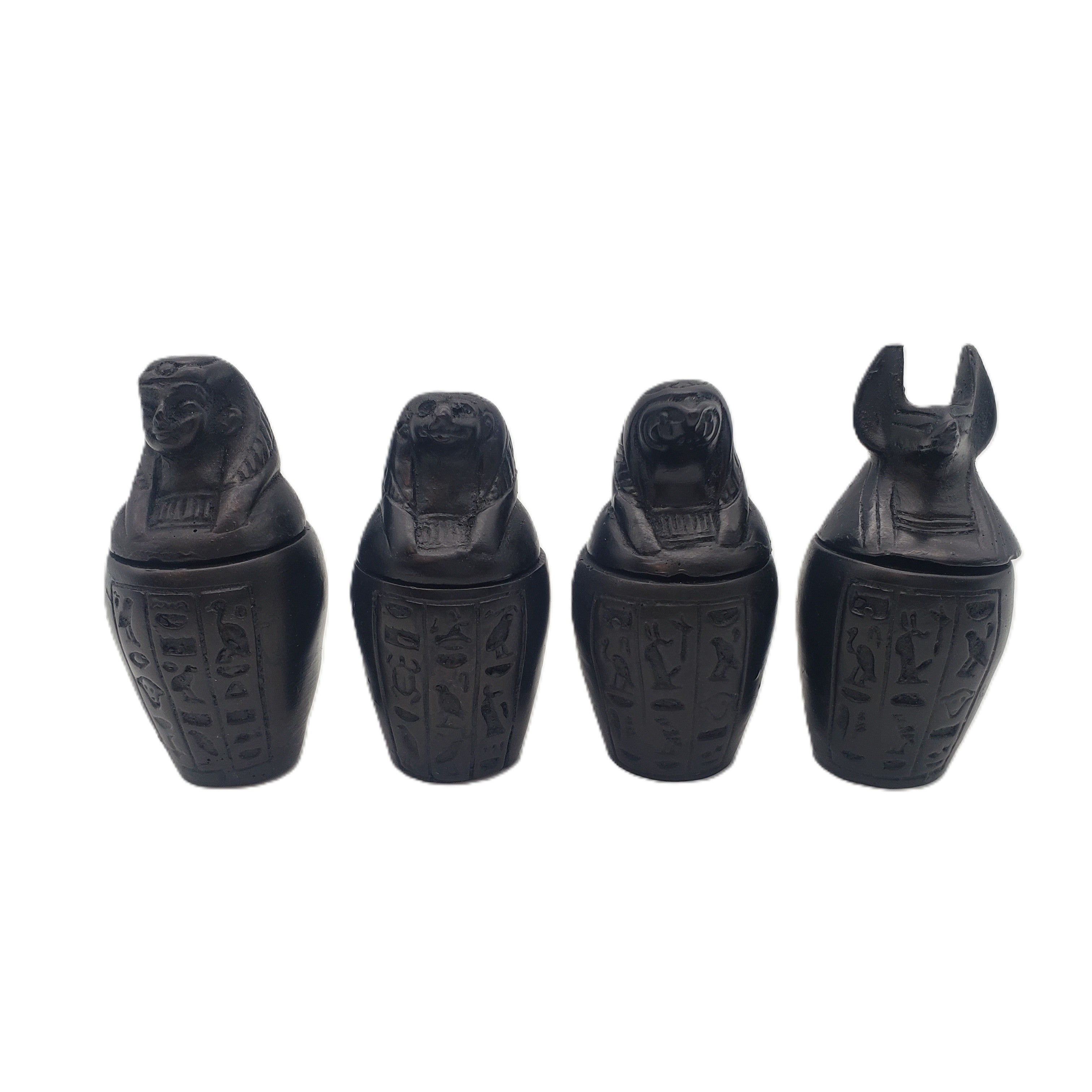 Four black canopic jars with hieroglyphics on a white background