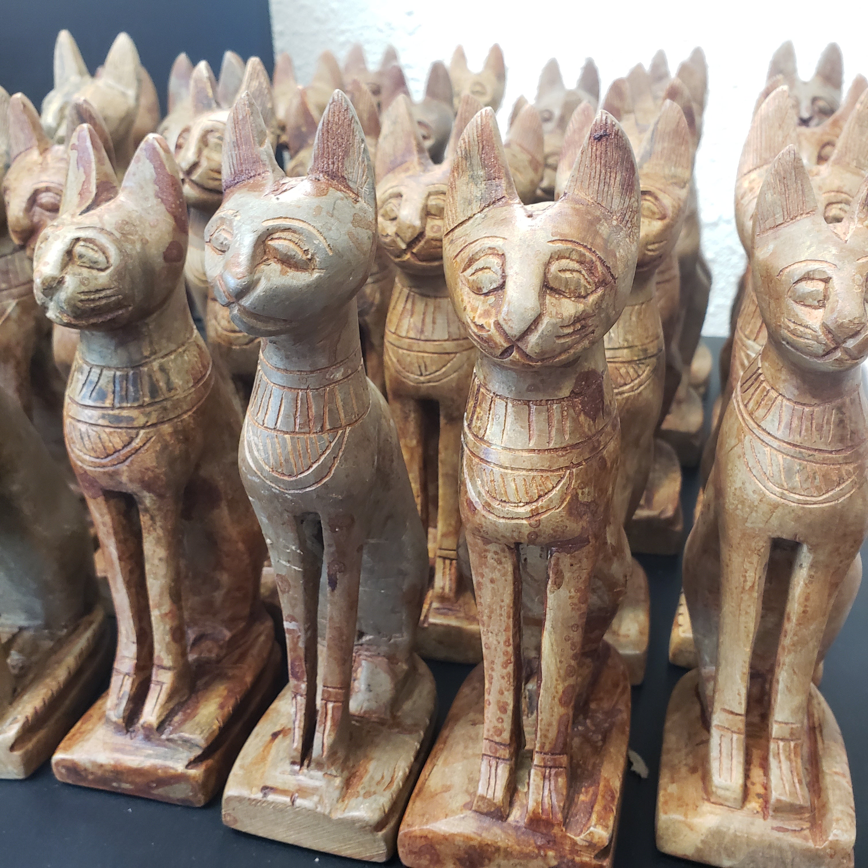 stone carved figures with animal heads on a dark background