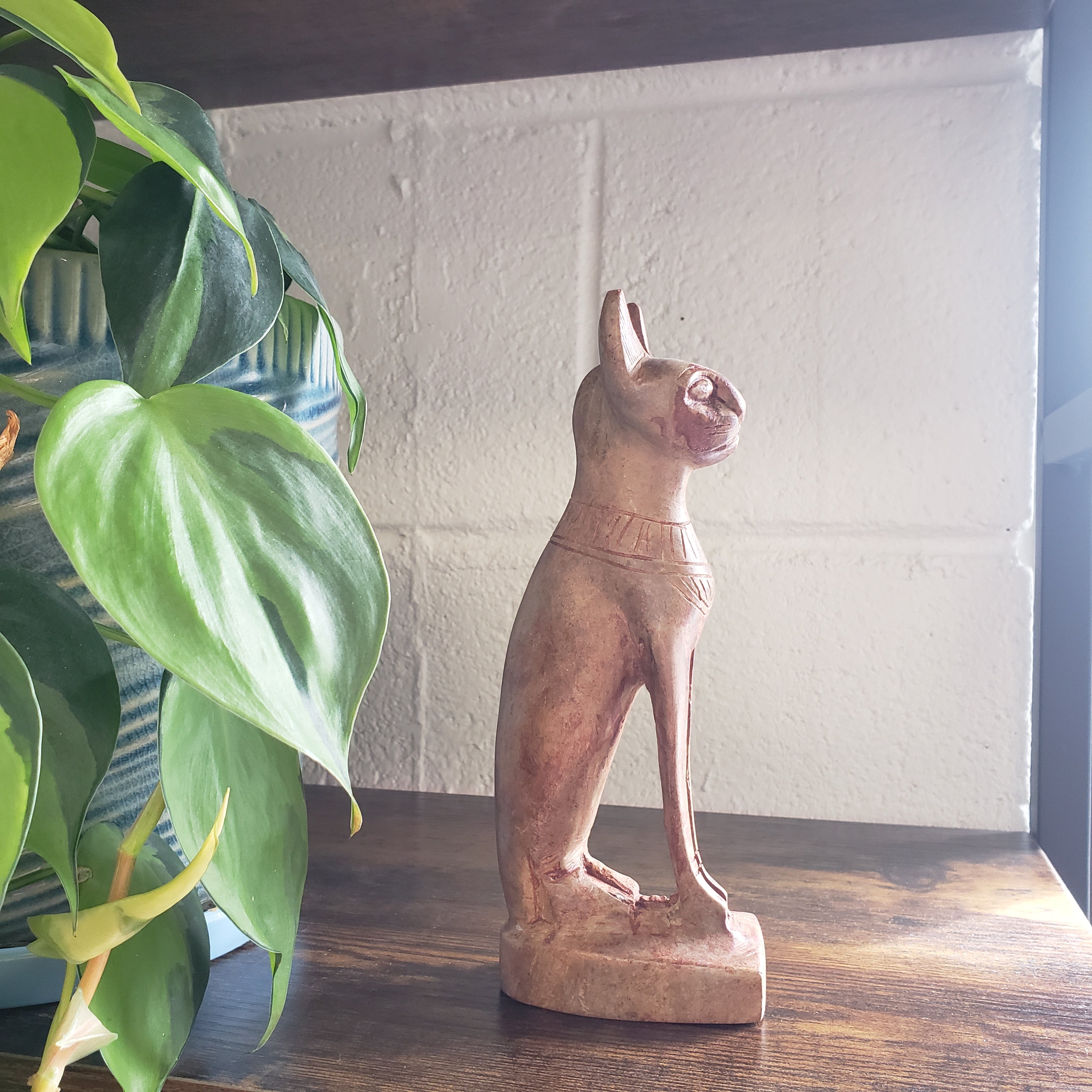 stone sculpture of a figure with a plant in the foreground