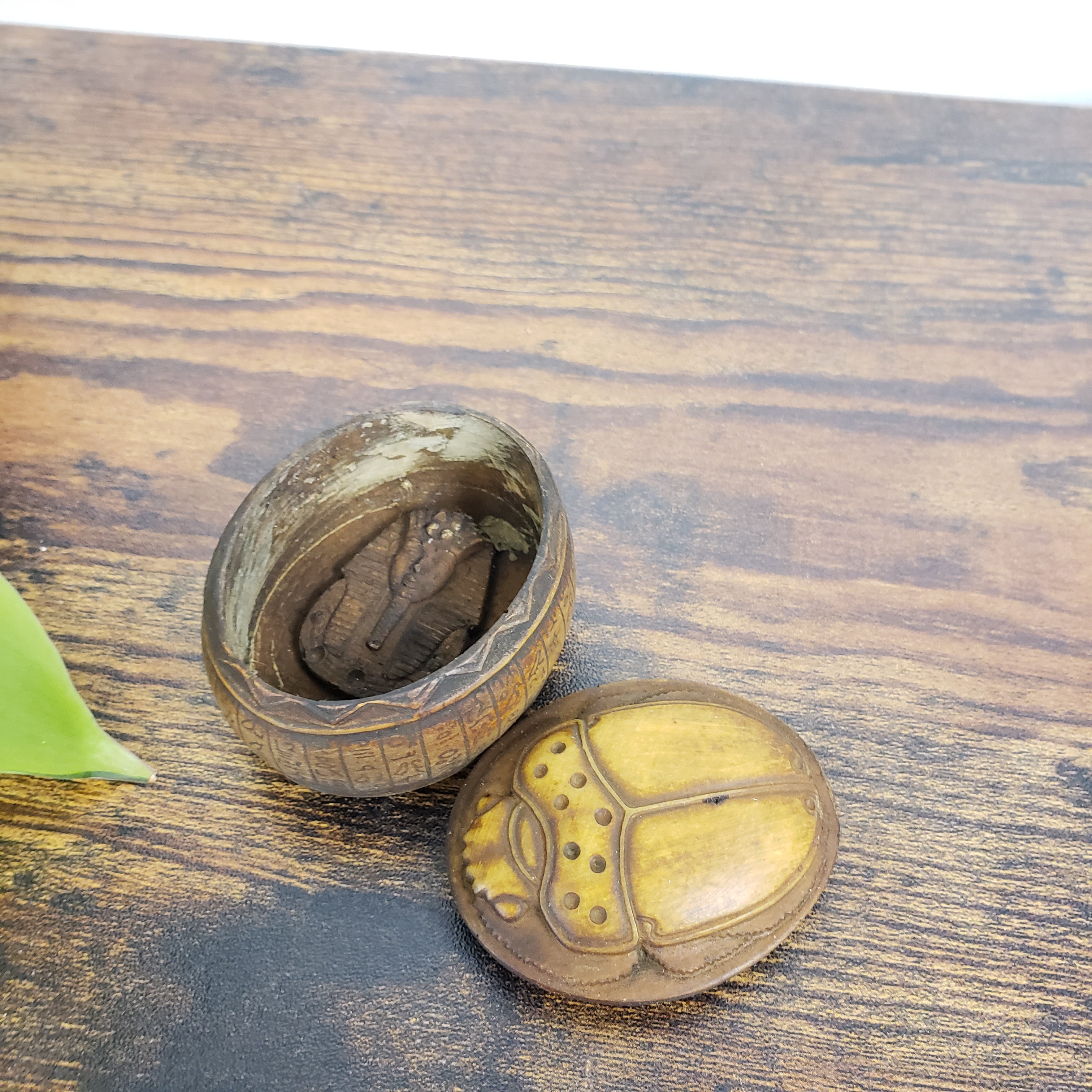 Egyptian scarab box with a natural finish on a wooden surface.