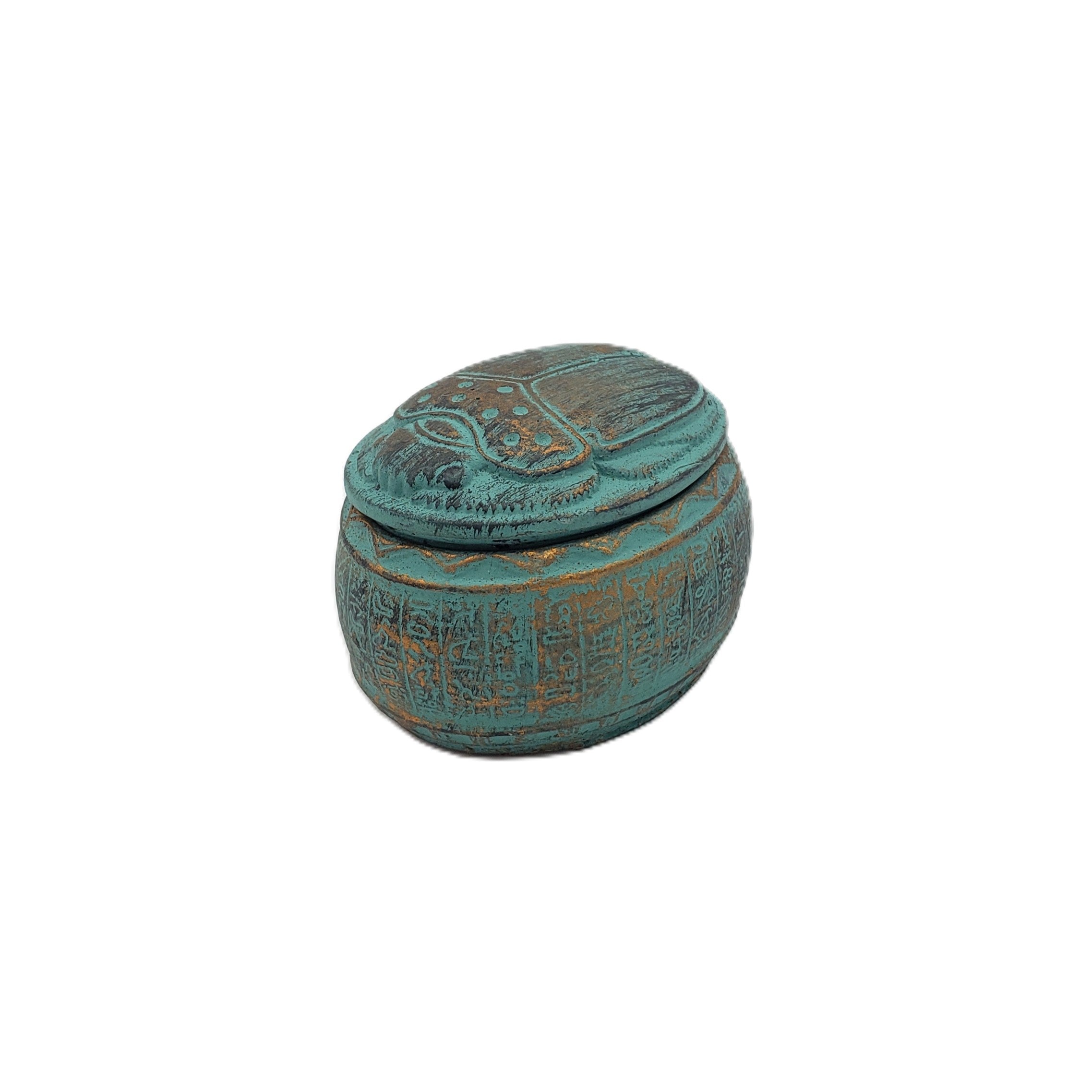 Decorative turquoise Egyptian scarab box with hieroglyphic designs on a white background