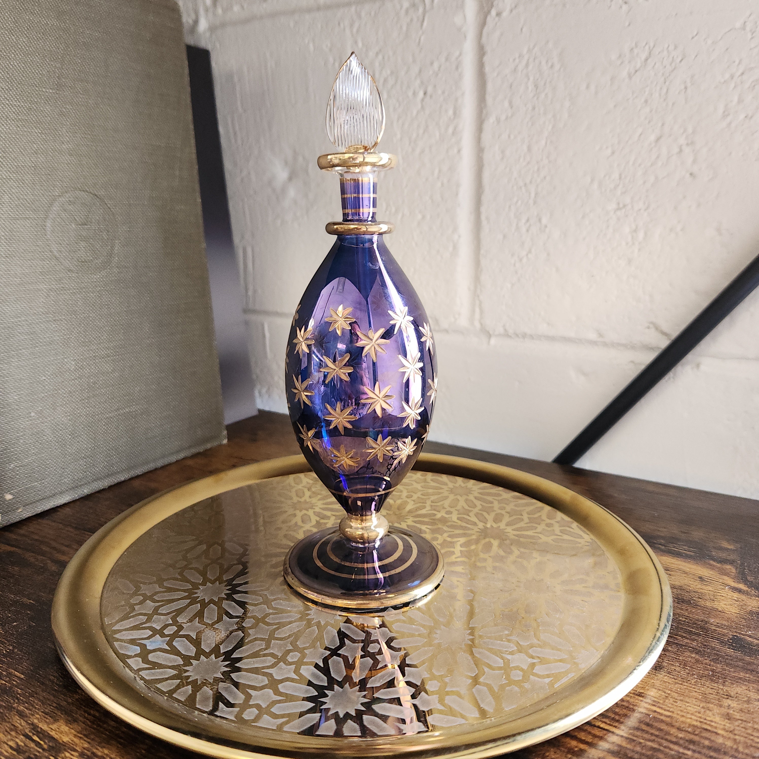 Decorative glass object with gold accents on a textured surface