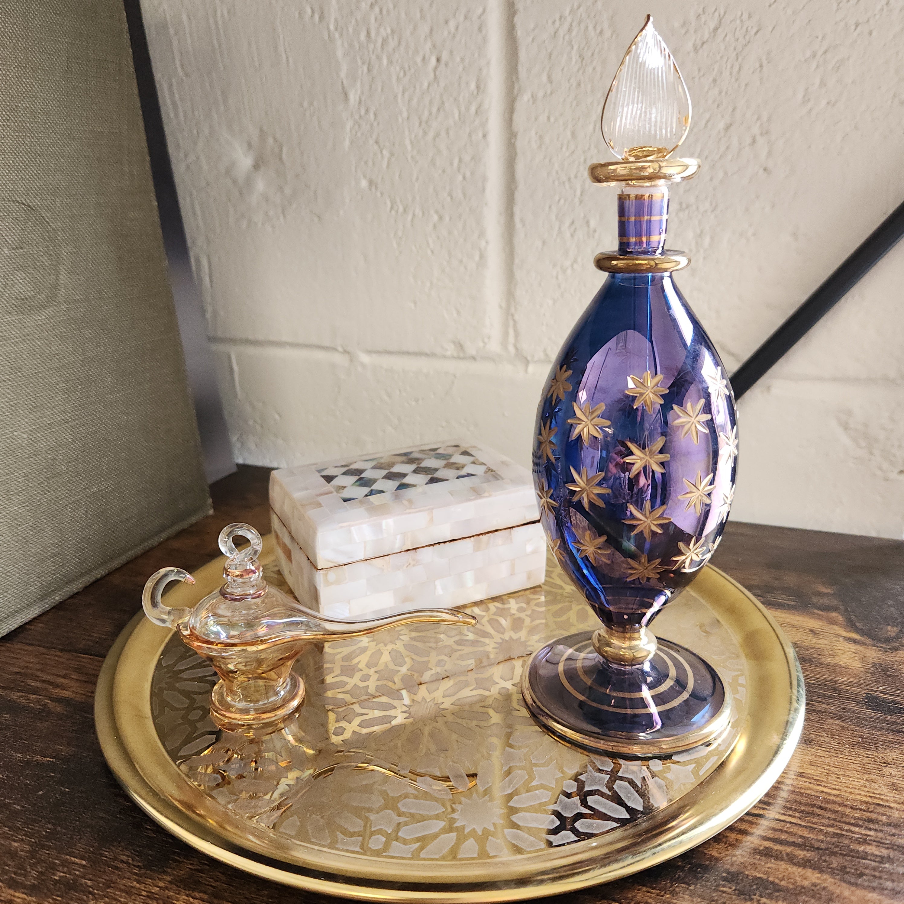 Decorative glass perfume bottle with gold accents on a wooden door