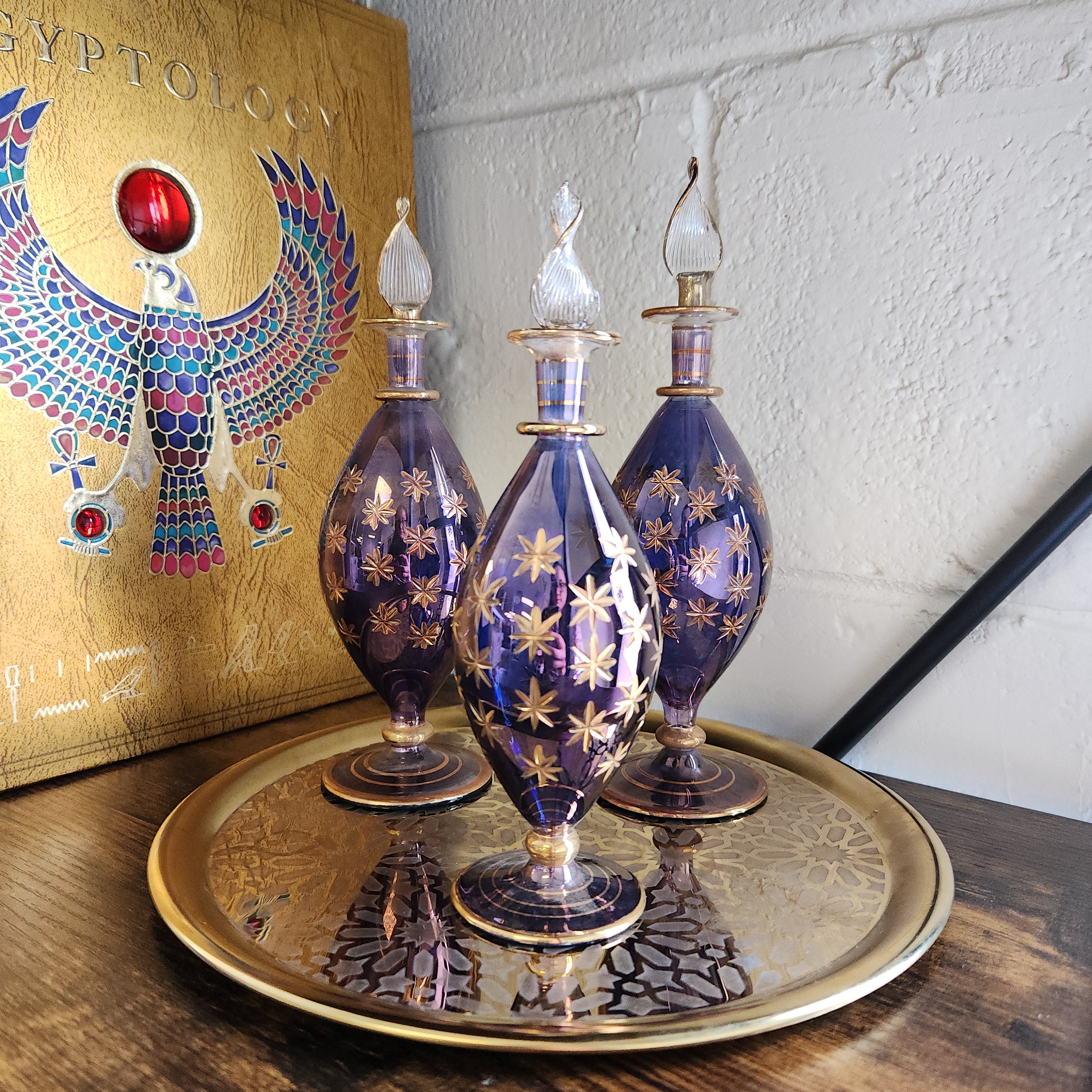 Decorative glass bottles with gold accents on a wooden surface