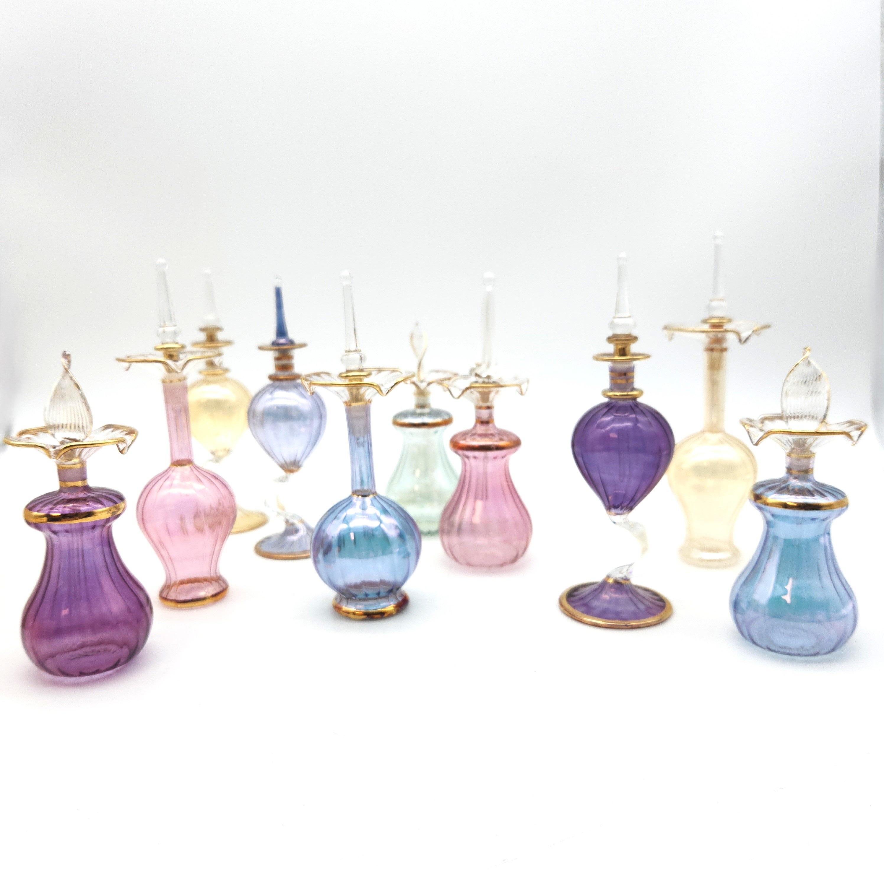 Collection of colorful glass bottles with metallic nozzles on a white background