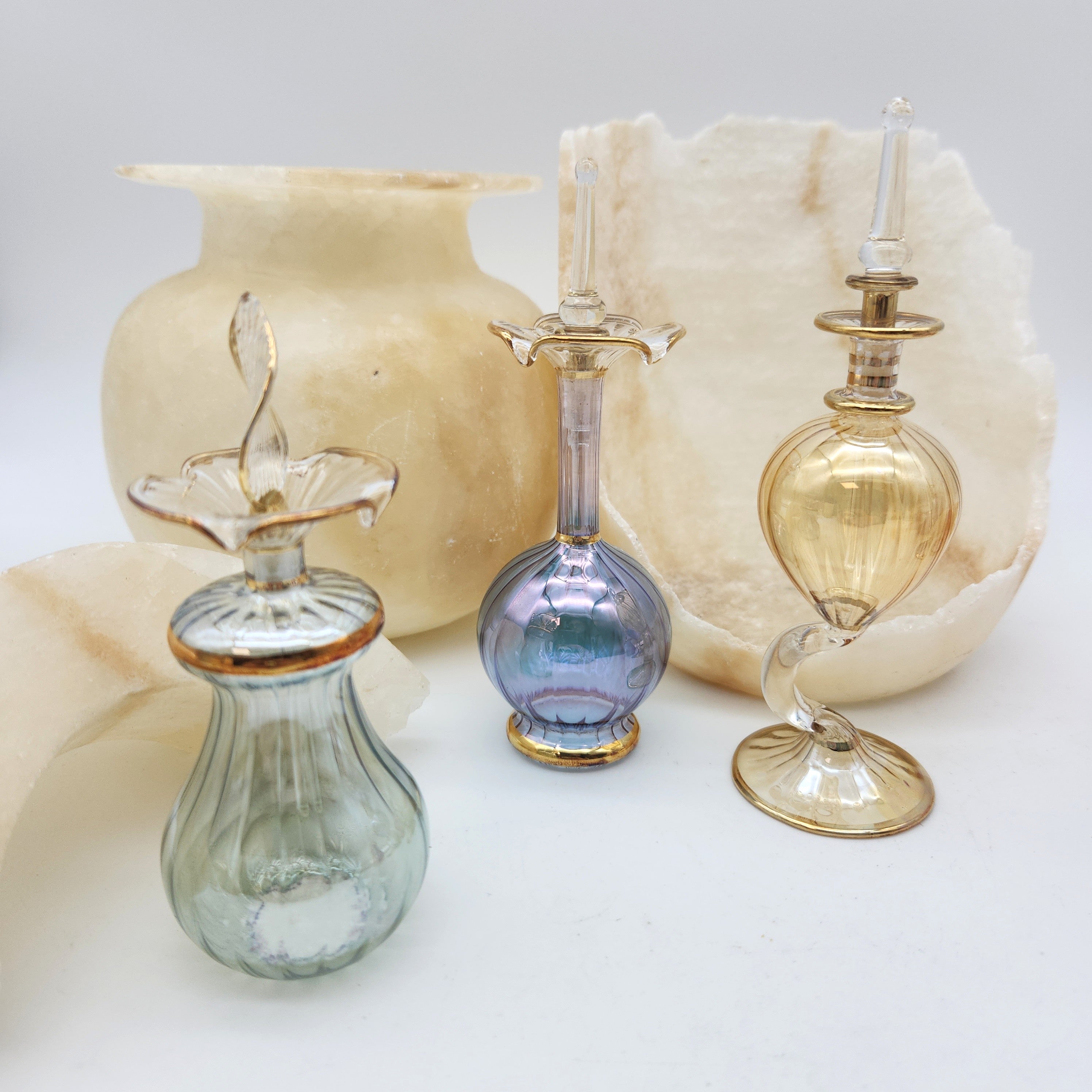 Set of glass bottles with decorative elements on a light background