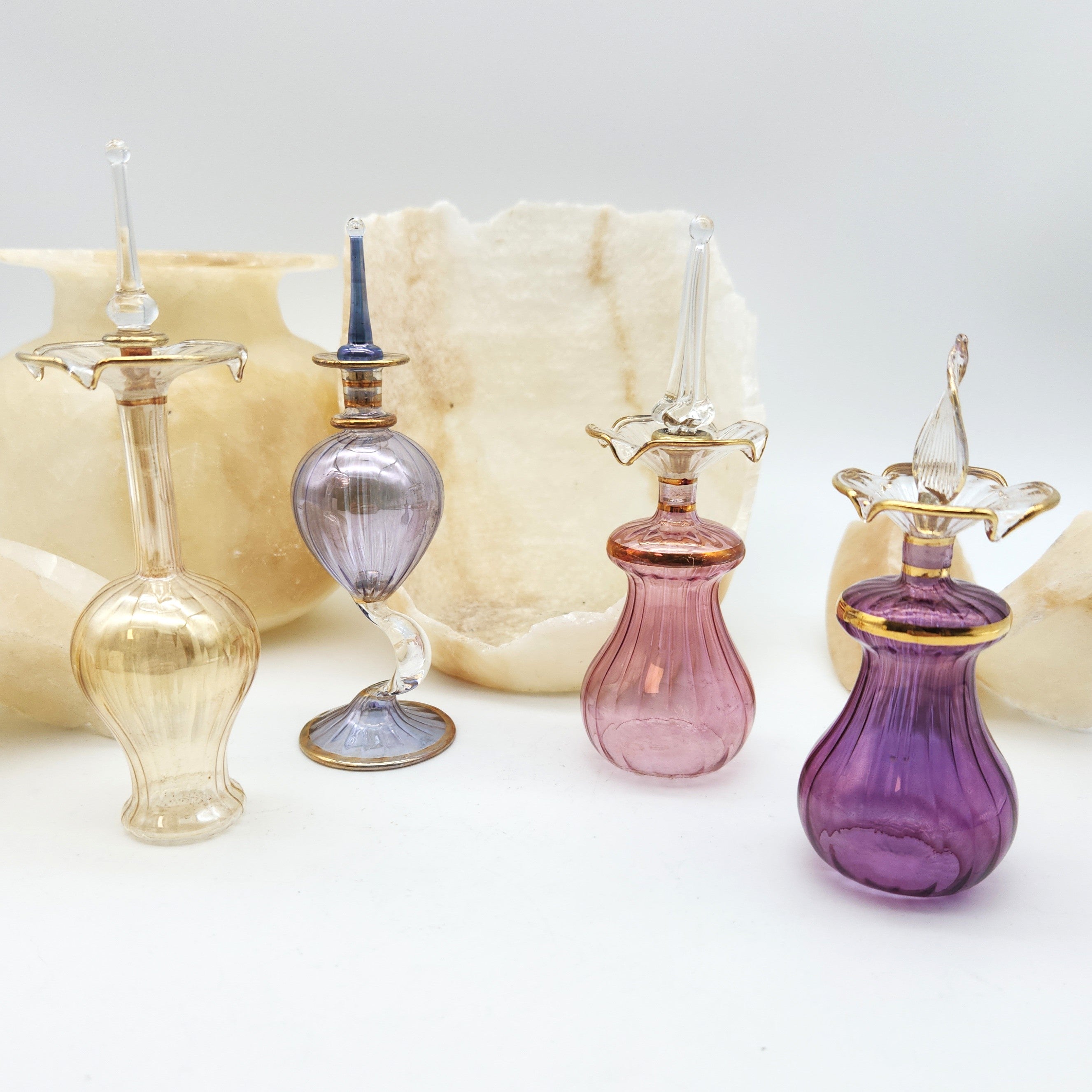 Set of colorful glass perfume bottles on a white background