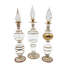 Three decorative glass perfume bottles with gold and white accents on a white background