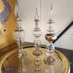 Decorative glass bottles with gold accents on a textured surface