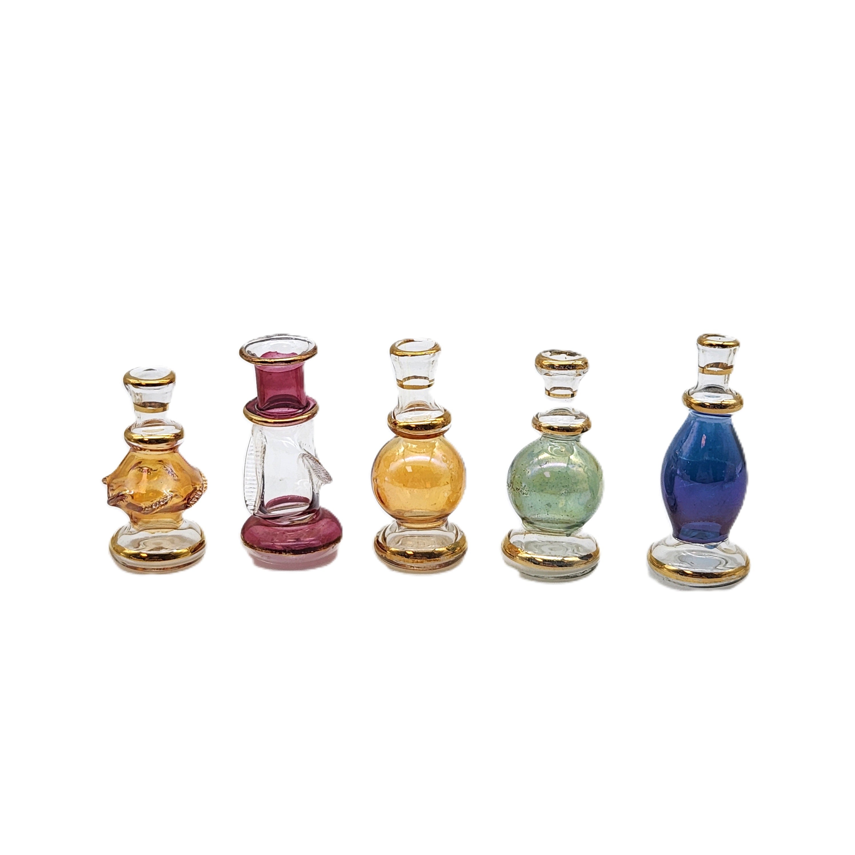 Set of six small glass bottles with colorful caps on a white background