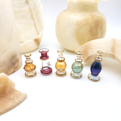 Set of small glass bottles with colorful liquids on a white background