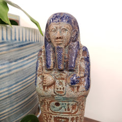Decorative object with intricate carvings on a striped surface