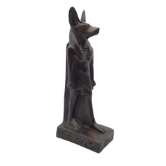 An ancient Egyptian Anubis statue, depicted as a jackalope with a dark bronze finish, standing on a rectangular base with hieroglyphic details, set against a plain white background.