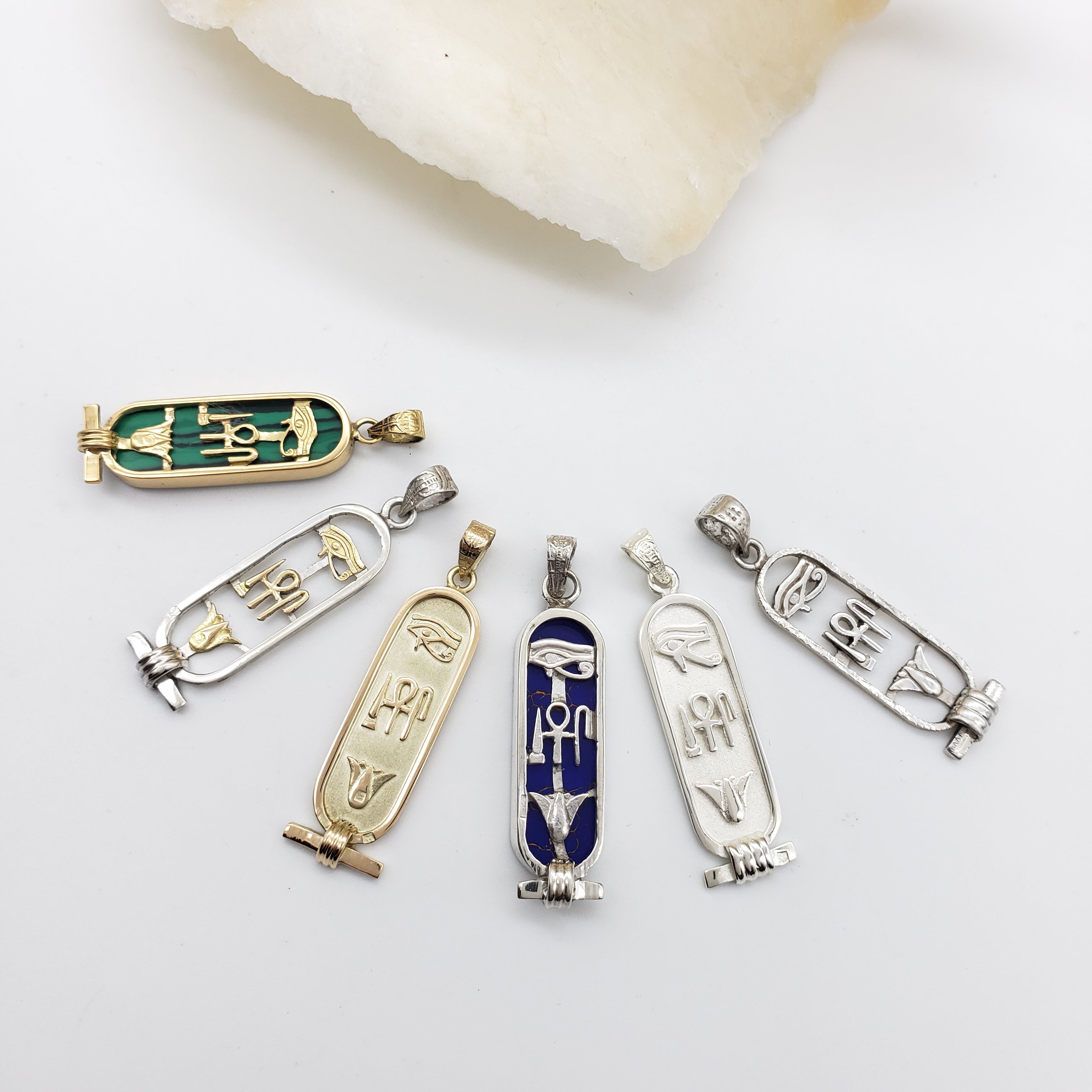 Collection of Egyptian-style pendants on a white background