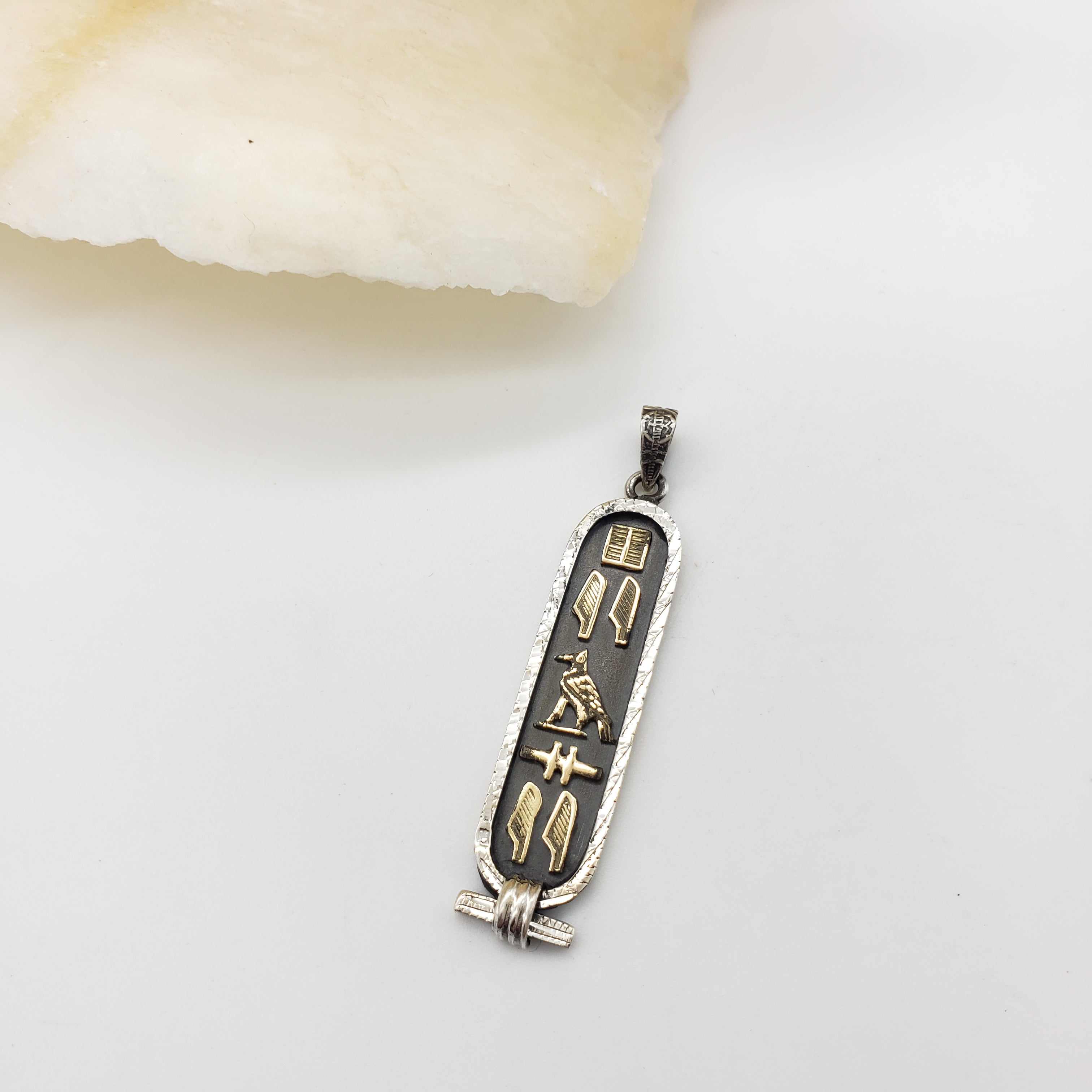 Decorative pendant with hieroglyphics on a light background