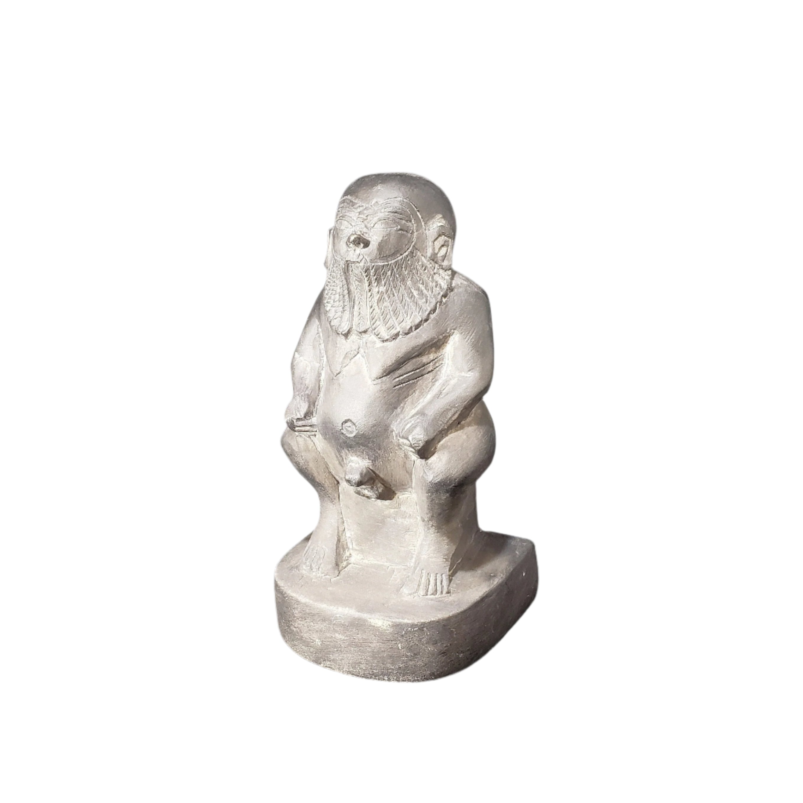 A hand-carved stone statue of the Egyptian God Bes, depicted as a dwarf with large ears, a long-haired and bearded figure, holding a rattle.